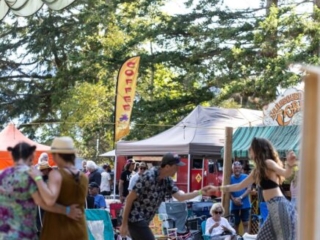 A photo of two festival goers dancing together, holding hands