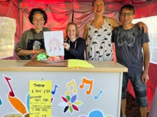 A photo of four people volunteering at the ticket tent