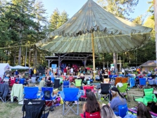 A photo of the stage with festival-goers and their camping chairs set up in front